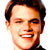 Static pixelated portrait of a smiling man with short dark hair against white background, rendered in low-resolution 256x256 pixels.
