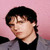 A 50x50 pixel animated contact sheet showing two frames of a music artist icon with pink and blue background sections, featuring a person in a gray jacket over black shirt on the left frame and stylized text on the right frame.