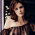 A pixelated image of a woman with long brown hair wearing an off-shoulder dress, positioned next to green text reading 'Original Icons .com' on a dark background.
