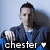 Pixelated image of a person in a dark jacket with light hair, holding a white object, with text 'chester' and a heart symbol below.
