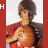 A person in a red shirt holds an orange basketball against a white background, with vertical red bars displaying changing text on the left.