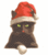 Pixelated dark cat wearing red Santa hat with white trim, green eyes, small pink nose, and light-colored paws on white background.