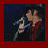 A person with dark hair sings into a silver microphone against a dark background, wearing a red and black outfit.