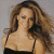 A split-frame contact sheet showing a woman with long brown hair in a black spaghetti-strap top on the left and green pixelated text "Original Icons .com" on a dark green background on the right.