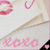 A static image of a white envelope with pink text and symbols, featuring 'xoxo' and a red lipstick kiss mark on the top left corner.