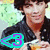 A person in a dark jacket holds an orange cup with steam, wearing a purple '3' symbol that alternates between cyan and green outlines.