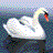 Pixelated swan with white body, yellow neck, and red beak floats on dark water against a checkered background.