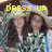 Two people with long dark hair stand side-by-side under a large light-colored hat, with yellow text reading 'DRESS UP' above them.