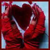 A person in a red hoodie forms a heart shape with their hands against a light blue background.