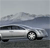 Pixelated image of a silver sedan on a road with a cloudy sky background, showing partial front and side views.