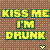 Pixelated text reads 'KISS ME I'M DRUNK' in yellow-green letters with dark green outlines on a checkered brown background, plus a small heart symbol.