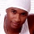Two side-by-side pixelated frames of a person wearing a white headwrap and dark clothing, with visible facial features and hand gestures in each frame.
