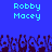 Pixelated blue background with two identical text blocks reading "Robby Macey" in light cyan, and a of dark purple pixel art hands at the bottom