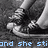 Black-and-white pixelated image of a person's lower legs and feet in sneakers, with partial blue text at the bottom.