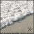 Pixelated beach scene with waves crashing onto shore, featuring light gray and white water against a sandy foreground.