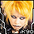 Pixelated close-up of a person with bright yellow hair and dark clothing, featuring the text 'KYO' in white block letters at bottom right.