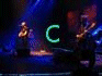Animated sequence showing band members on stage with blue lighting, group poses in front of equipment, and text elements cycling through 'C', 'Co', 'Coldp', 'Coldpl', 'Coldplay' in green or purple.