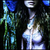 A pixelated close-up of a person with long dark hair wearing a light blue patterned top and a white pendant necklace against a dark background with blue and green vertical elements.