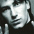 Pixelated grayscale image of a stylized human face with high-contrast lighting and visible dithering patterns.