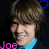 Pixelated image of a person with brown hair wearing blue clothing, featuring two heart symbols above the head and pink text reading "Joe" at bottom left.