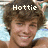 Pixelated image of a person with brown curly hair and light skin, wearing a dark top, with the text 'Hottie' overlaid in white pixelated font above the head.