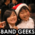 Two people in a pixelated image, one wearing a Santa hat and white shirt, the other with dark hair, both smiling against a dark background with text at bottom.