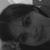 Black-and-white pixelated image of a person's face with dark hair, visible eye, and partial facial features against a light background.