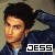 Pixelated image of a person with dark hair tied back, wearing a blue jacket over light clothing, with the text 'JESS' in bold black letters on white background at bottom right.