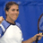 Pixelated static image of a person holding a tennis racket against a blue background, wearing a white and light blue shirt.