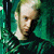A person with light hair in a dark green shirt against a teal background, shown across where the head position shifts slightly left to right
