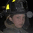 Pixelated image of a person in a firefighter helmet with yellow lights, set against a cyan background with pink text elements.