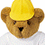 Brown teddy bear wearing yellow hard hat and white shirt against green background with pixelated text.