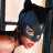 Static 48x48 pixel icon of a woman in Catwoman costume with black mask, blue hair, red lips, and partial chest visible against dark background.