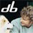 Pixelated static icon featuring a black background with white text "db" and partial visible figure in light colors on the right side.