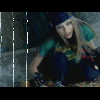 Animated sequence of a person with long blonde hair wearing a dark beanie, green shirt, and blue jeans in a dimly lit stone setting.
