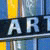 Pixelated image showing large light blue letters 'AR' on dark background with yellow and blue vertical stripes above.