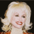 Pixelated close-up of a smiling figure with blonde hair, red lips, and a light-colored top against a dark background.