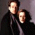 A contact sheet of two animated frames showing a pixelated image of two people on the left and green text reading "Original Icons .com" on the right against a gray background.