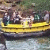 Pixelated image of a yellow boat on water with blurred figures in the background.