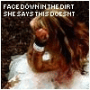 A woman with long brown hair in a white dress lies face down on dirt with text above her head.