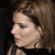 Pixelated close-up of a person's face with brown hair, closed eyes, and a neutral expression against a dark background.