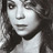 Static grayscale pixel art of a person's face with long dark hair, rendered in low resolution with dithering and anti-aliasing effects on the edges.