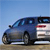 Pixelated side view of a dark blue sedan with silver accents on a light brown ground under a clear blue sky.