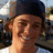 A pixelated image of a person wearing a dark cap and light shirt, with text overlays on blue and gray backgrounds.