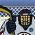 Pixelated static icon showing a hockey player in dark blue uniform with yellow stick and golden helmet, set against checkered background with small blue sphere detail.
