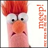 A close-up of a pink puppet with orange hair, large white eyes, and an orange nose, next to vertical red text reading "meep!" and "mee meh mi meh".