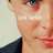 Pixelated close-up of a person's face showing eyes, nose, mouth, and ear with visible text overlay on the cheek area.