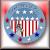 Pixelated circular icon with blue and white striped vertical bars, red and blue dots, and a multicolored gradient background.