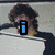 A person with dark curly hair and a black jacket over yellow clothing appears in four , each showing different text overlays