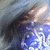 Pixelated static image of a figure with dark hair and blue clothing against a light background, rendered in low-resolution digital style.